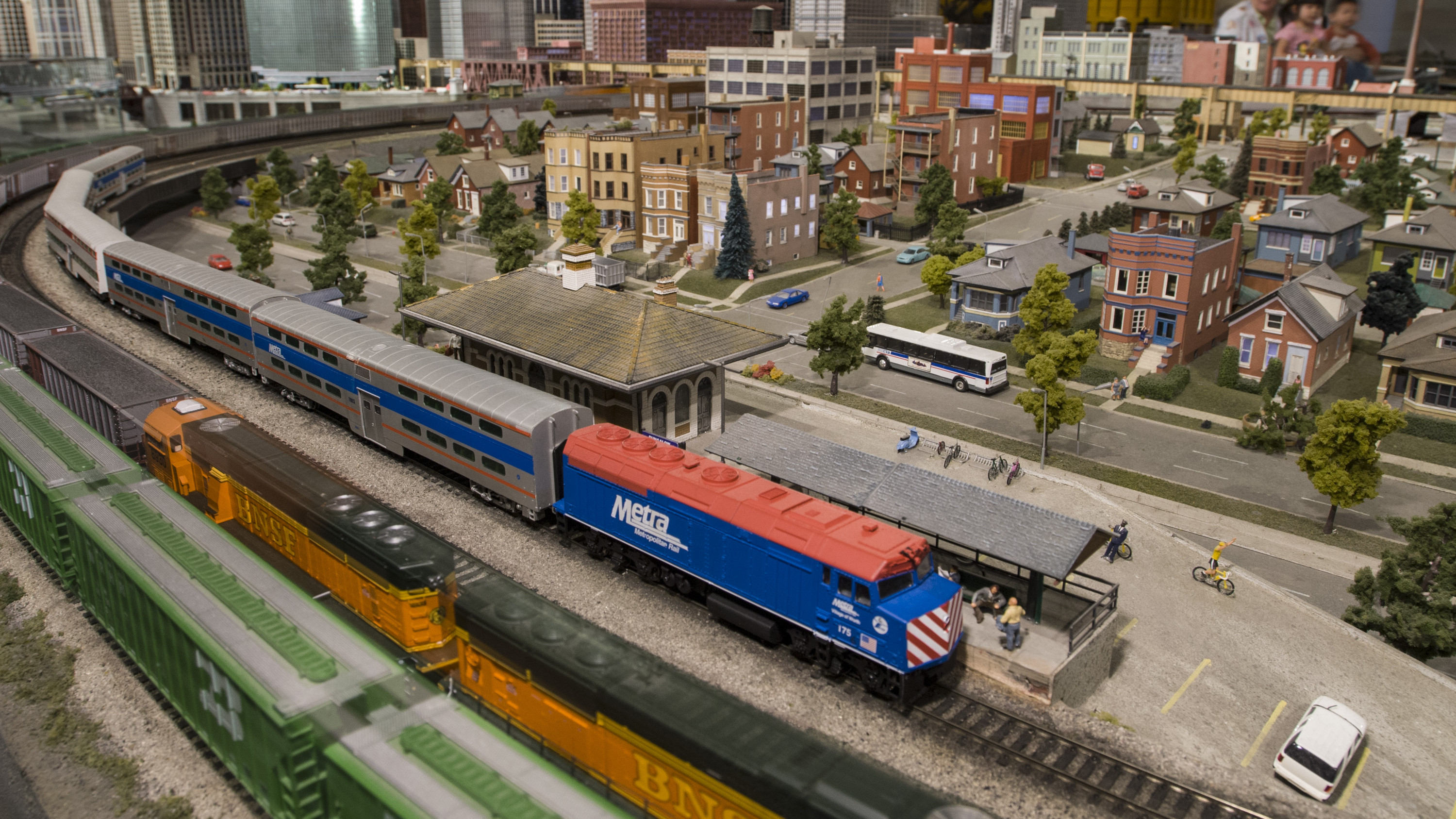 A model Metra train rounds a corner around a neighborhood in The Great Train Story. 